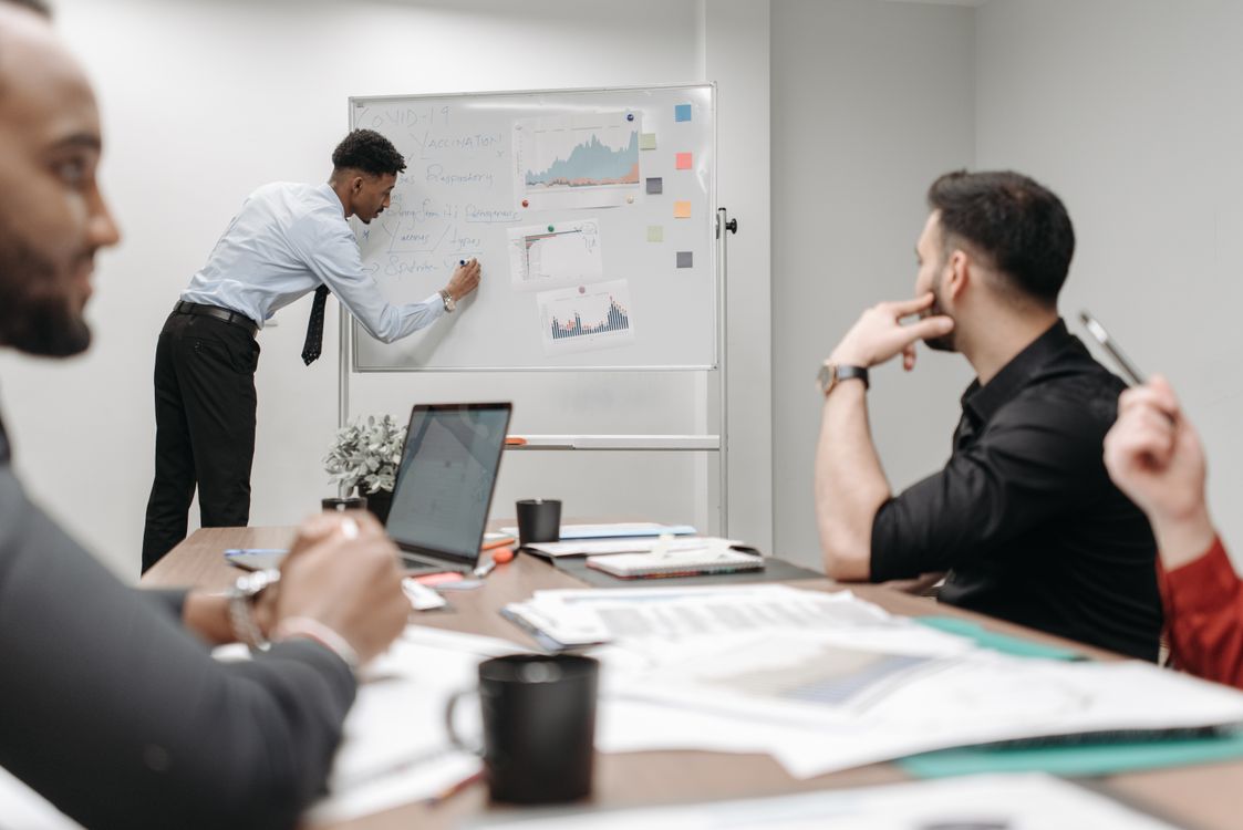 Equipo de profesionales en reunión de negocios discutiendo estrategias en oficina moderna