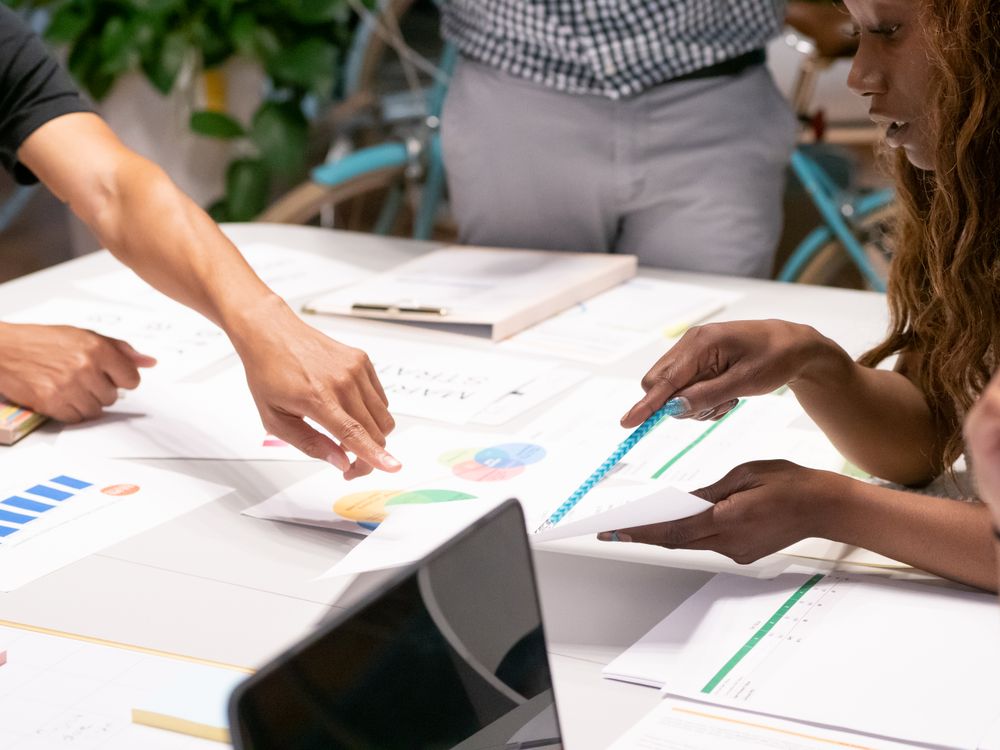 Equipo de marketing analizando gráficos y datos de rendimiento en reunión colaborativa