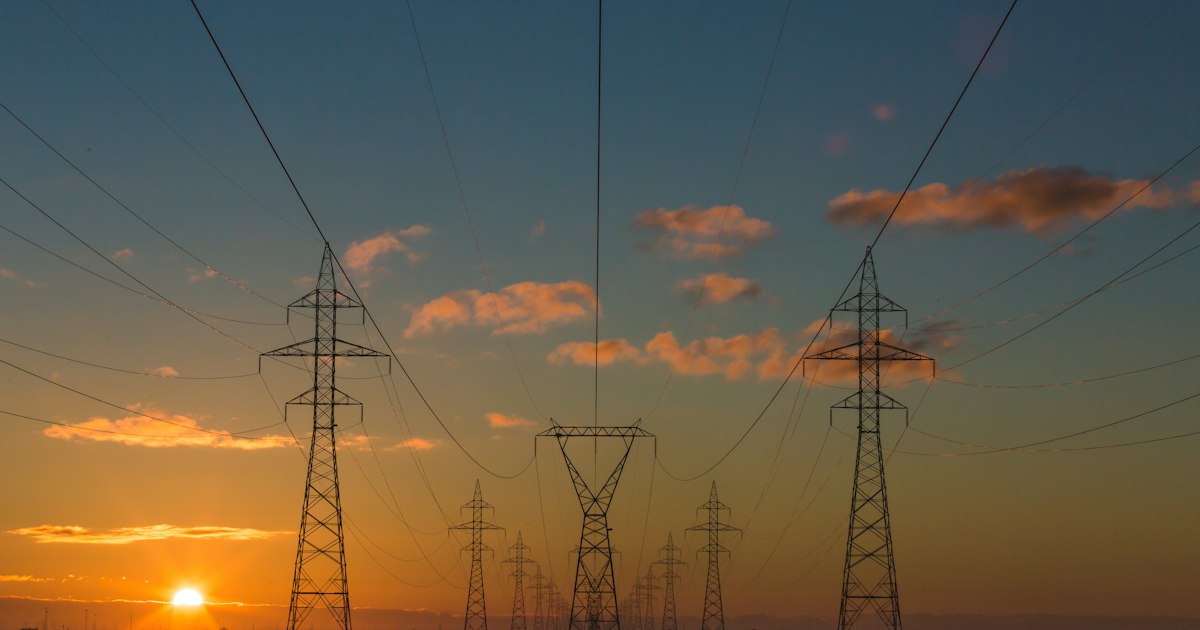 Subestación eléctrica industrial con estructuras metálicas y equipos de transmisión al atardecer