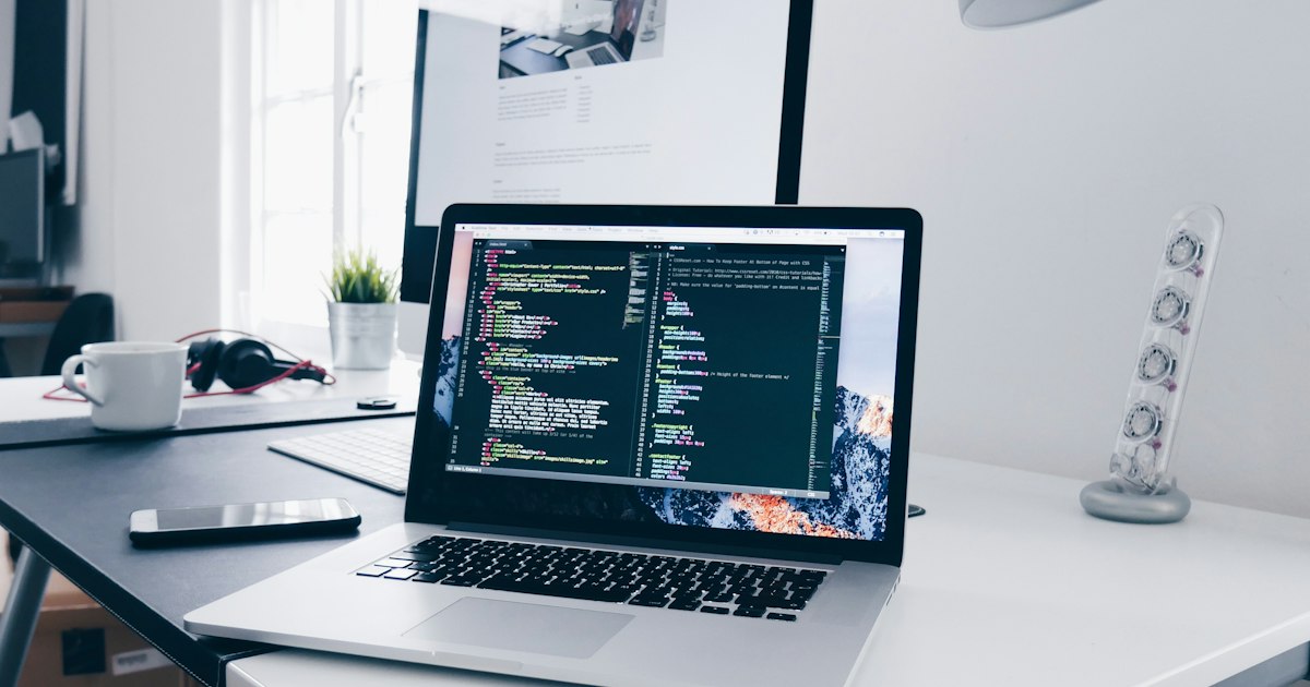 Pantalla con código de desarrollo web sobre un escritorio de trabajo