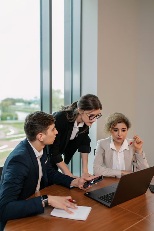 Profesionales de negocios analizando datos en una laptop durante una reunión de trabajo