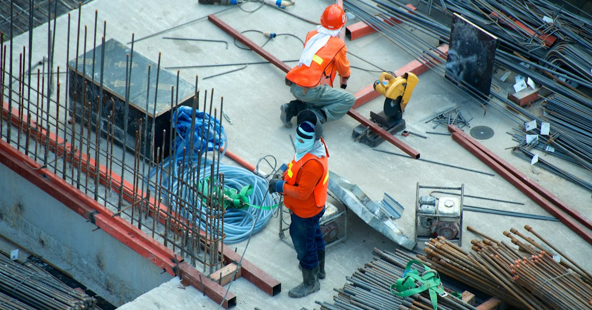 Ingenieros revisando planos de construcción en un proyecto industrial.